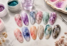 Blooming gel designs featuring colorful watercolor, floral, and marble nail art on a manicure setup