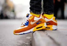 Orange, yellow, and white athletic sneakers styled with black jeans for a modern streetwear look, showing how to wear sneakers from gym wear to everyday casual outfits.