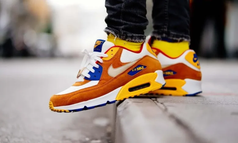 Orange, yellow, and white athletic sneakers styled with black jeans for a modern streetwear look, showing how to wear sneakers from gym wear to everyday casual outfits.