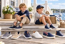 Nautica Boys Fashion Sneakers featuring stylish kids wearing navy blue sneakers with various trendy shoe designs displayed on a seaside wooden deck.