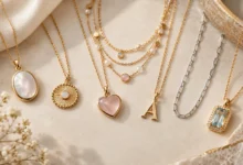 Kendra Scott Necklace collection featuring elegant gold and silver pendant necklaces with colorful gemstones on a beige marble background.