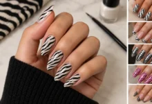 Zebra print nails featuring glossy black stripes on a nude base with stylish manicure designs and a modern beauty aesthetic.
